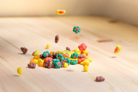 Colored crunches falling on the wooden table. Soft focus with small amount of DoF