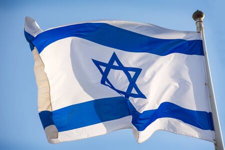 Israel official flag, blue white with magen david on the blue sky background.の写真素材