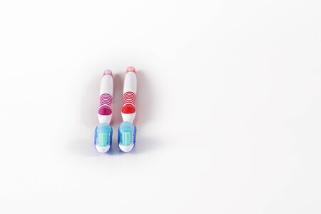 Two toothbrushes with blue toothpaste on white background ready to care.の写真素材