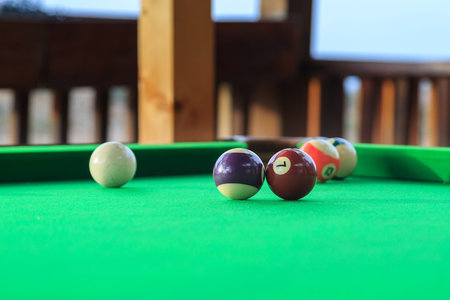 Billiard balls on the green pool table. Small amount of focus isolates number seven ball.