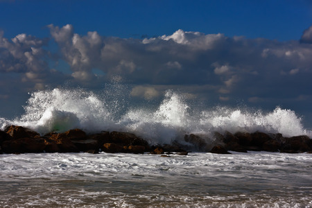 Sea storm on the sunset beach. Stones in the water.の写真素材