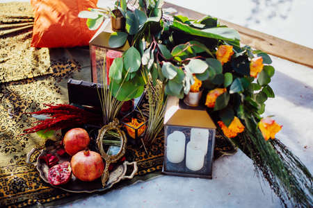 Wedding decor: rings and garnet on a tray, next to a candle holder with candlesの写真素材