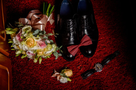 Wedding accessories of the groom on a burgundy backgroundの写真素材