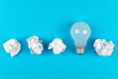 Great idea. Concept with crumpled paper and a light bulb, on a blue backgroundの写真素材
