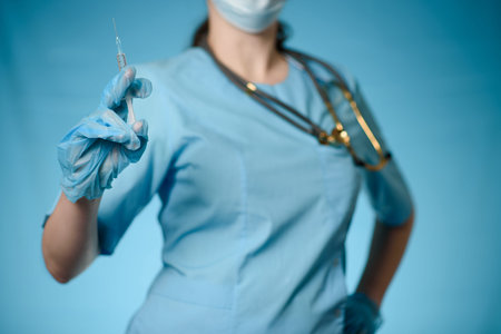 A nurse holds a syringe in her hands.Close-up