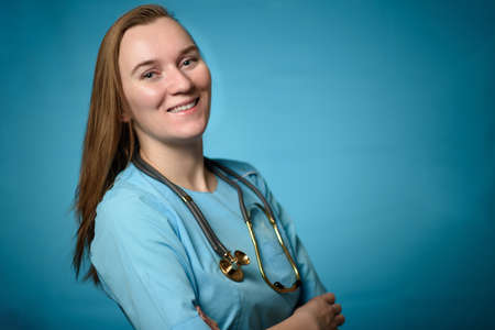 A doctor on a blue background holding a stethophonendoscopeの写真素材