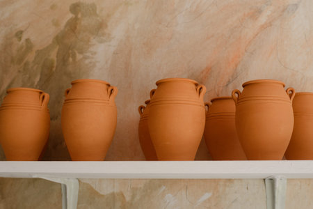 Clay jars stand on a white shelf. High quality photo