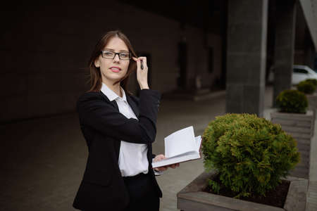 A businesswoman with glasses makes a note in a notebook.Management concept.の写真素材