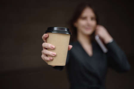 A paper cup of coffee with a place for text in the hands of a girlの写真素材