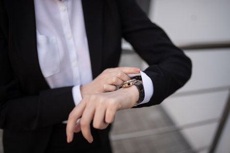 A business woman looks at her wristwatch. Close-upの写真素材
