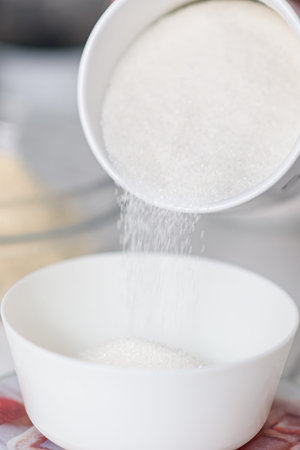 Sugar pours into the container close-up