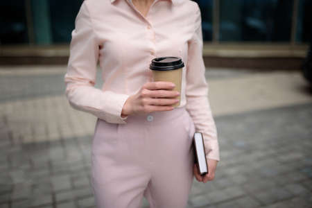 A young woman with a notebook and coffee on the street.Close-upの写真素材