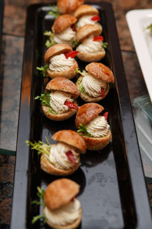 On the tray are beautiful cakes decorated with cream and a piece of strawberryの写真素材