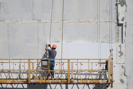 The builder insulates the house from the outside.Construction elevator.