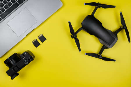 Layout of the modern traveler: Camera,Drone,Memory cards,PC on yellow backgroundの写真素材