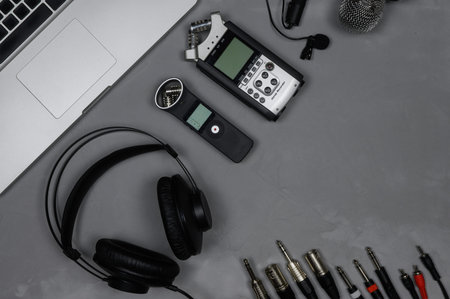 Layout laptop, headphones, recorders,microphone, cables on a gray background.の写真素材