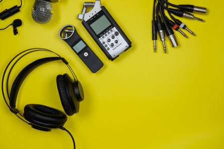 Laptop layout, headphones, recorders,cables on a yellow background.Copy space.の写真素材