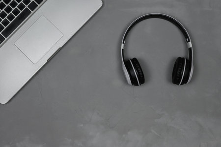 Layout of a laptop with stereo headphones on a gray background.の写真素材