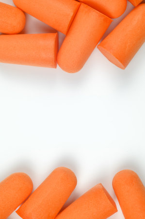 Frame made of orange earplugs on a white background. Close-up. The concept of getting rid of noise in a loud place, hearing protection. Copy space.High quality photoの写真素材