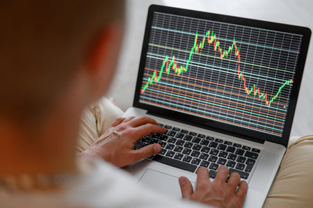 Close-up of a man watching a data index chart on a monitor. A man analyzes the stock market....