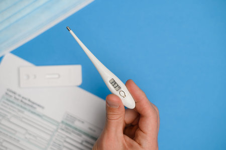 In the male hand is a thermometer with a high temperature (Celsius).Test kit for viral disease...