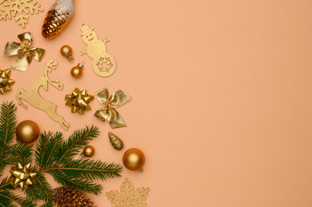 Christmas, winter composition. Flat lay of golden christmas decorations and fir tree on beige background. Flat lay, top view, copy space. Concept of christmas, winter, new year. christmas wallpaper.の写真素材