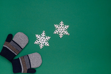 Layout of warm winter children's gloves and snowflakes on a blue background.The concept of winter, winter outdoor recreation. Top view.Copy spaceの写真素材