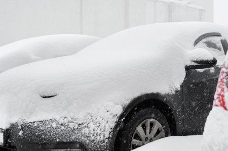 A car covered in snow after a heavy snowfall, close-up.Snow cyclone, heavy rainfall.の写真素材