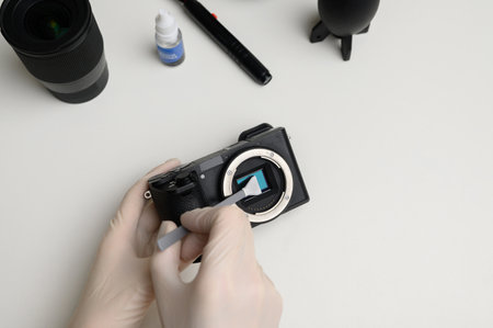 Cleaning the camera cleaning sensor swab to clean the sensor from dirt.Cleaning and maintenance of the mirrorless camera sensor. Care concept for professional photography equipment.の写真素材