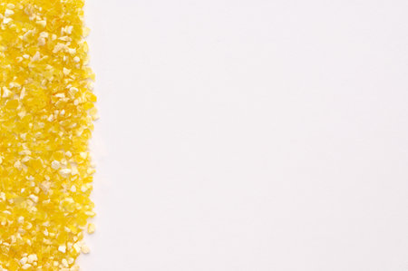Macro photo of dry yellow corn porridge on a white background. Healthy, delicious food, source of amino acids, minerals, vitamins, natural antioxidantの写真素材
