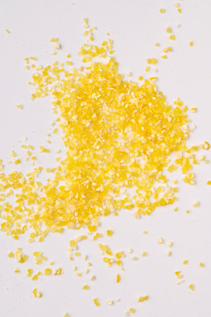 Macro photo of dry yellow corn porridge on a white background. Healthy, delicious food, minerals, natural antioxidantの写真素材