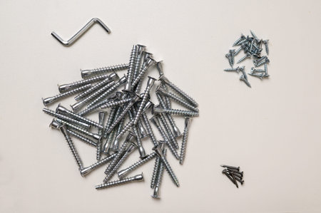 Top view of bolt, hex wrench, furniture assembly screw on white background. The concept of...