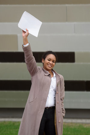 African american woman manager in business attire rejoices in a deal against the backdrop of a...
