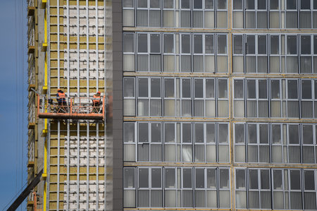 Workers sheathe the outer walls of the building with insulation.Insulation of the facade of the building.Exterior finishの写真素材