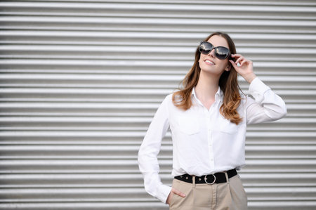 Young woman in summer clothes and sunglasses posing on a gray background.Summer concept, vacationの写真素材