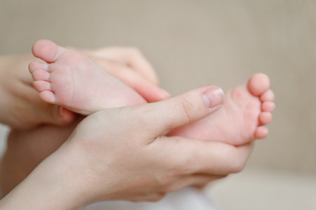 Baby feet in mothers hands. Maternal love for her baby. Maternity leave, motherhood, happy childhood concept.の写真素材