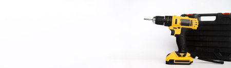 Banner, electric cordless yellow drill screwdriver and black carrying case on a white background....