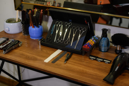 Hairdressing supplies on table, scissors, combs, hair dryer, razors and other accessories....