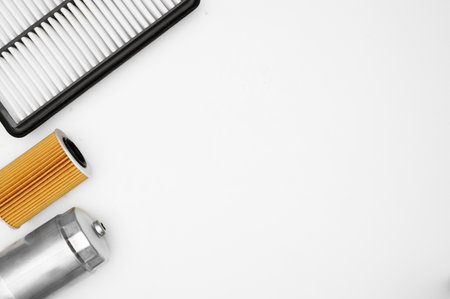 Layout of car filters on white background. Car oil filter, air filter and fuel filter top view. Auto parts replacement concept, car maintenance, car service. Copy spaceの写真素材