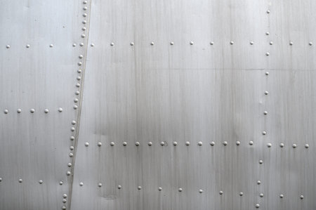 Close-up of the skin of a light aircraft, rivets on duralumin. Concept of aircraft modeling,...