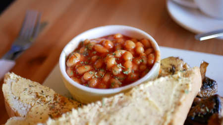 English breakfast with baked beans, toasted bread and mushroomsの写真素材