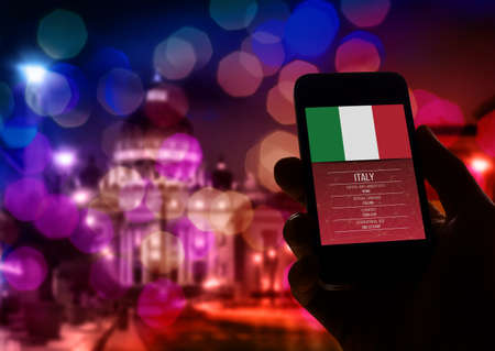 Hand holding smartphone with Rome St Peter Vatican city background.の写真素材