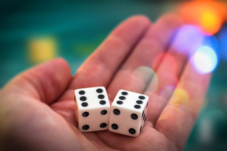 Hand holding white dices showing numbers 6
