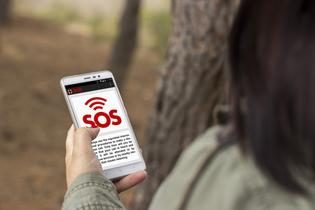 Girl lost in the forest asks for help through an application with her smart phoneの写真素材