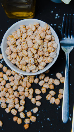 Chickpeas in a white bowl on a black background.の写真素材