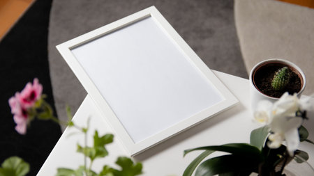 White frame mockup on the table with a flower, top viewの写真素材