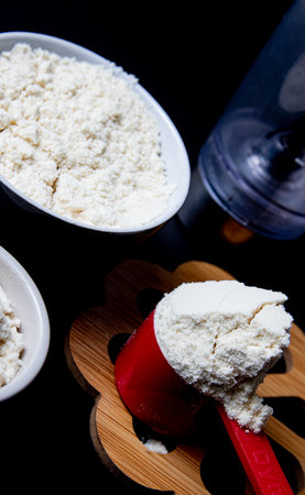 Flour in a measuring cup on a black background. Close up.の写真素材