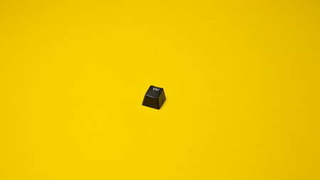 Black computer keyboard isolated on yellow background. Copy space for text.の写真素材