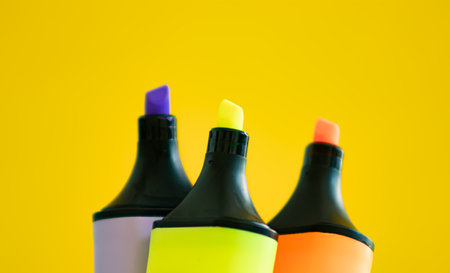 Colorful highlighter pens isolated on yellow background. Close up.の写真素材