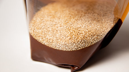 Quinoa seeds in a plastic container on a white background closeupの写真素材